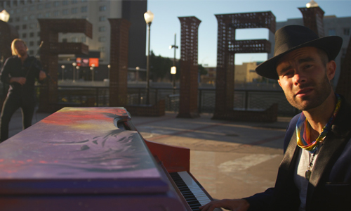 Artist outside playing the piano